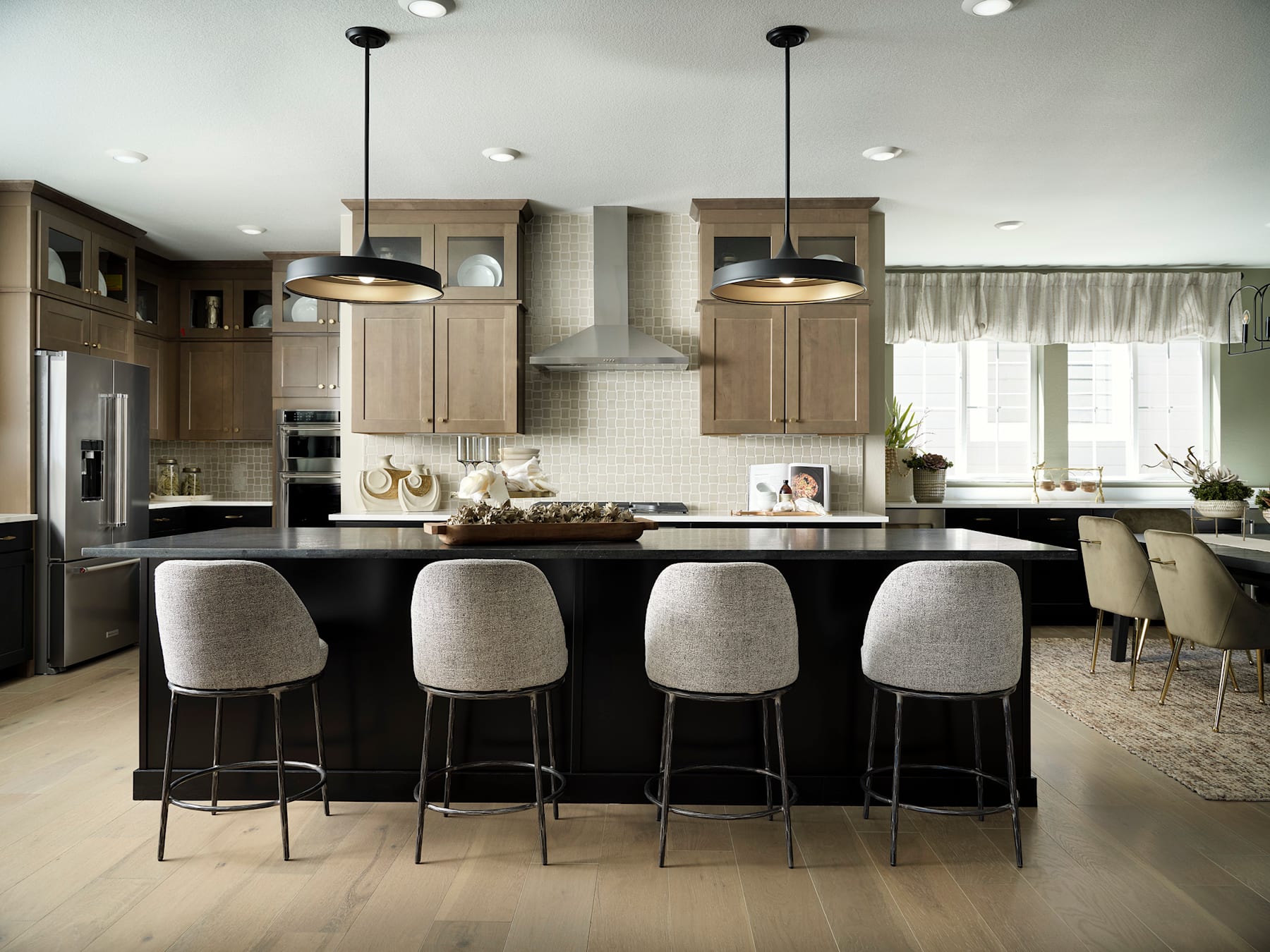 A modern and spacious kitchen with a large island, wooden cabinets, and pendant lights, featuring a clean and minimalist design.