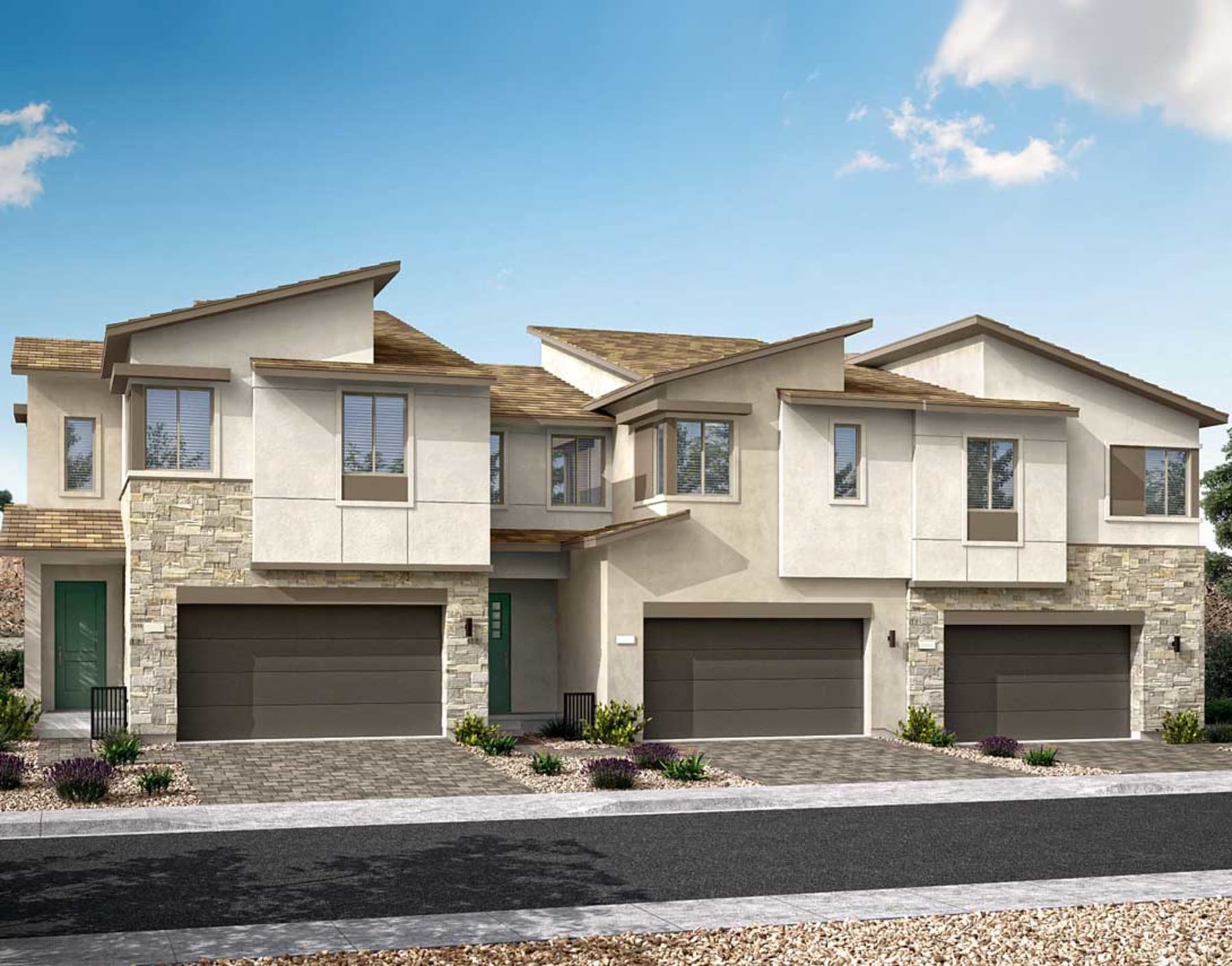 The image depicts a row of modern, two-story townhouses with stone and stucco exteriors, set against a clear blue sky with some clouds. The townhouses have attached garages and well-landscaped front yards, creating an attractive and cohesive residential development.