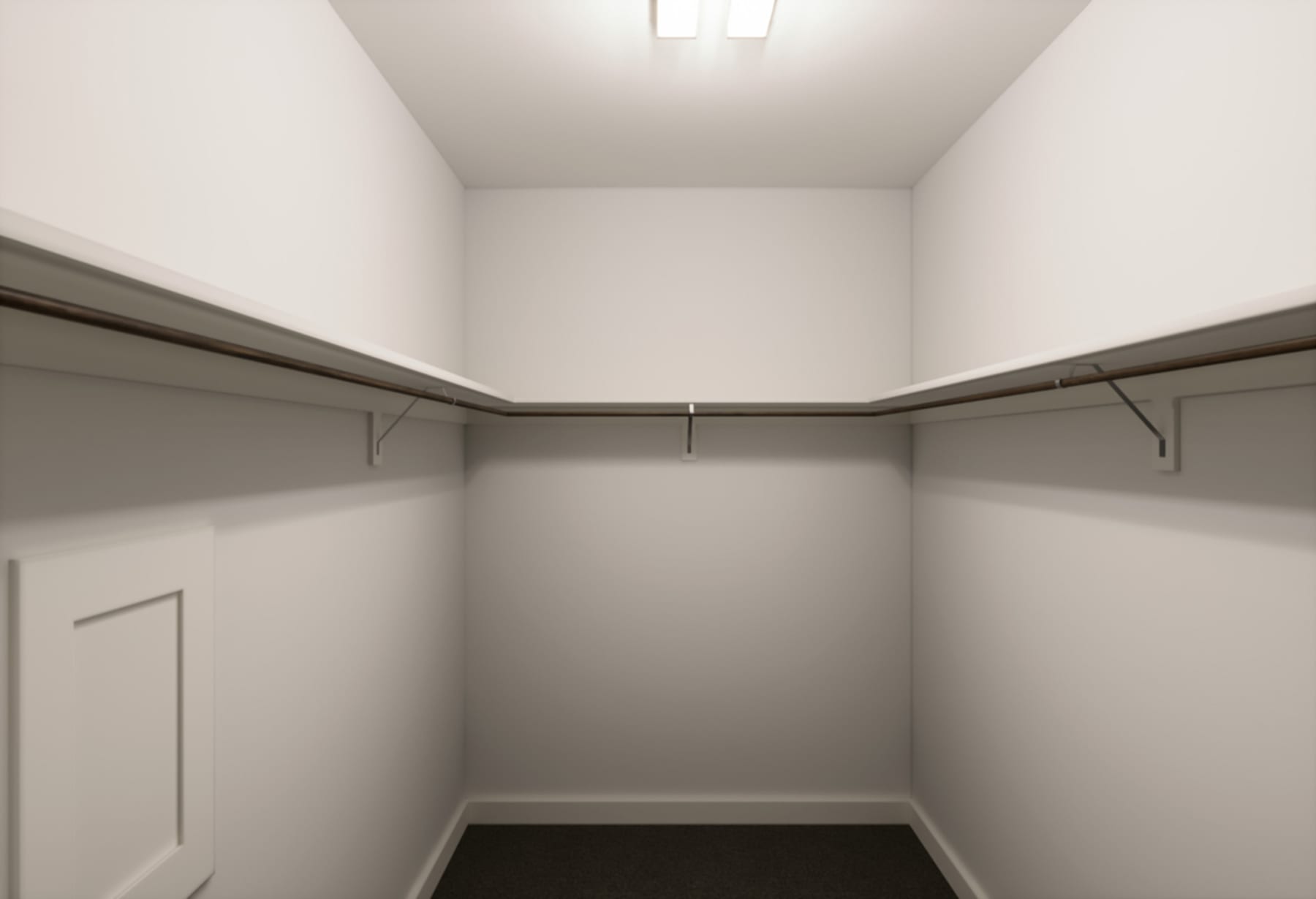 A simple, minimalist closet space with white walls, a ceiling light, and metal hanging rods for storage.