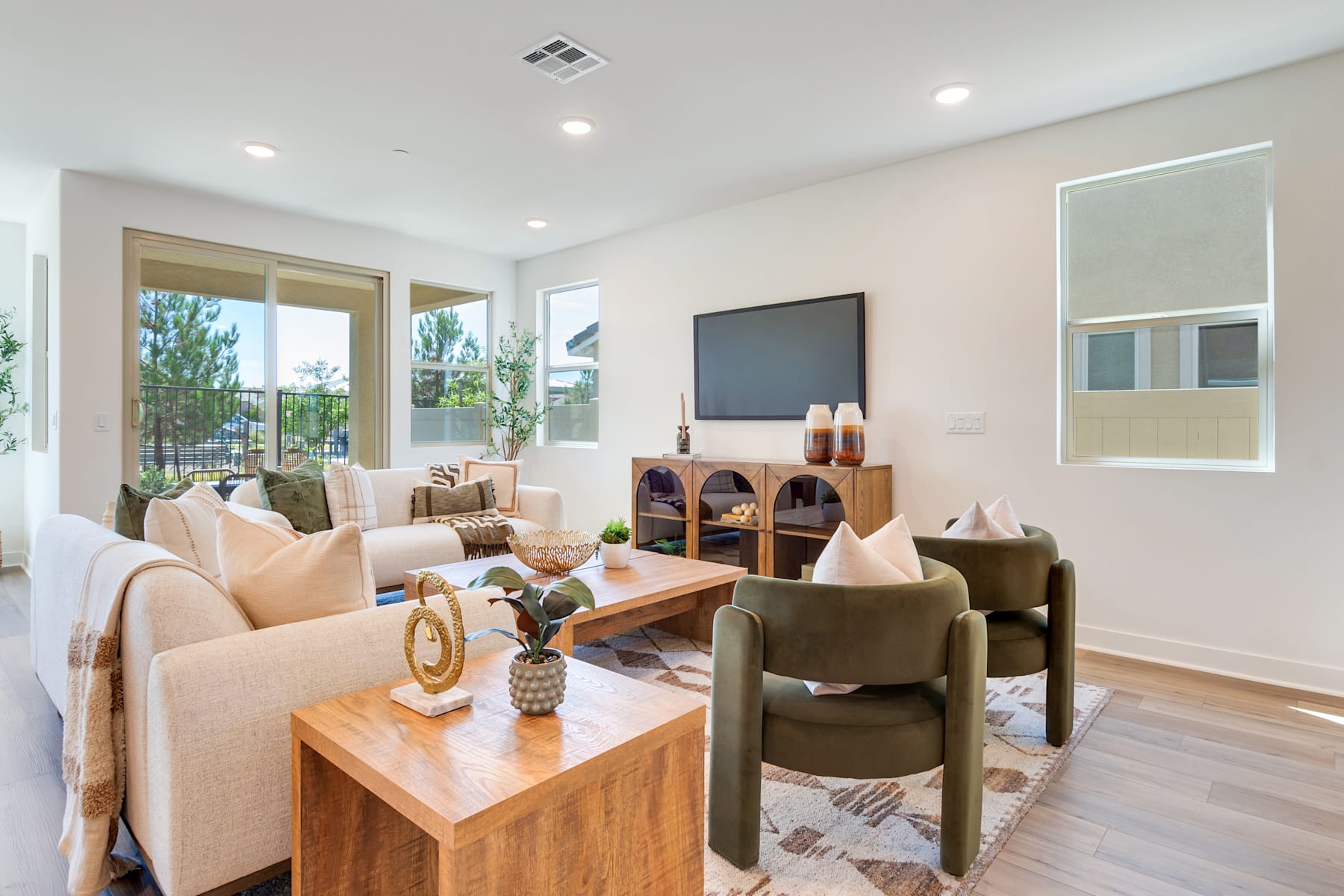 A cozy and inviting living room with comfortable seating, a large TV, and a wooden coffee table surrounded by various decorative elements.