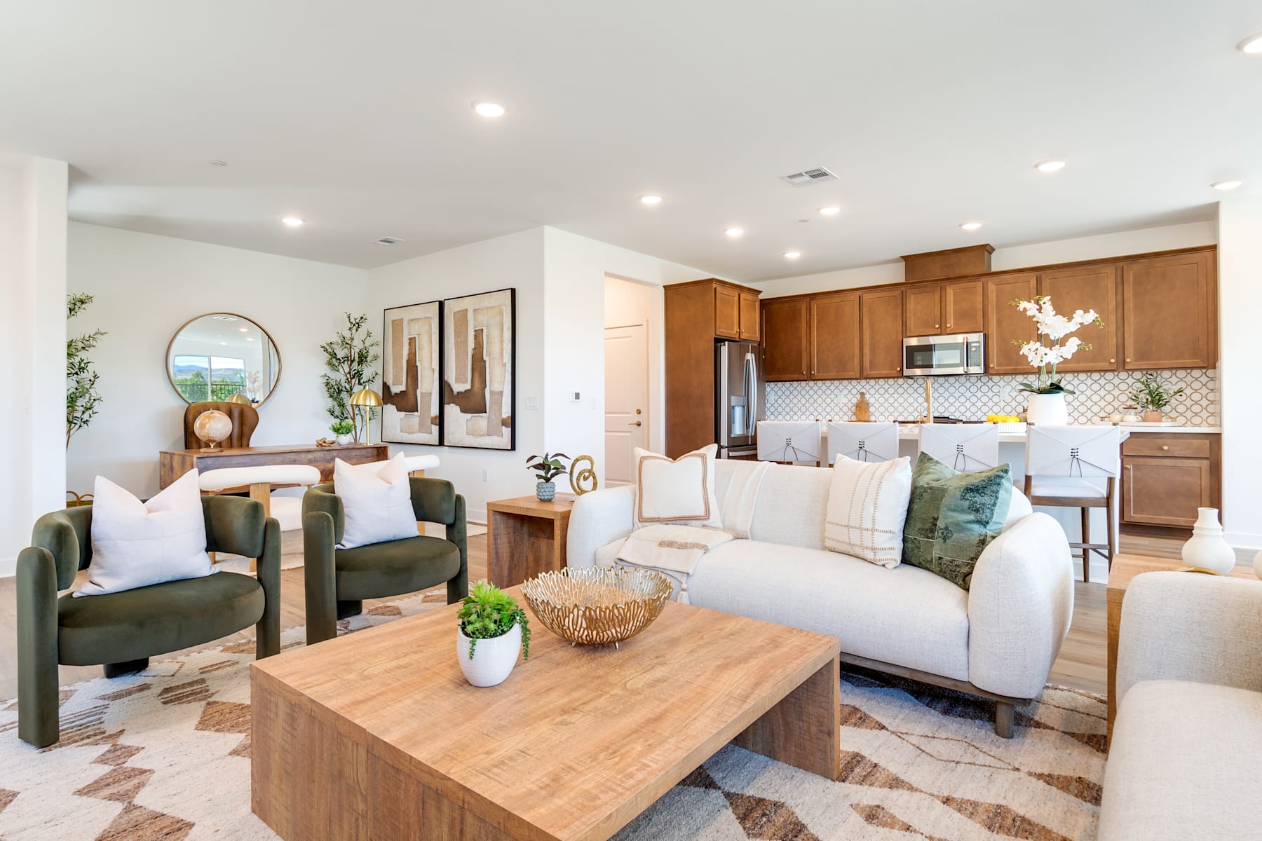 A cozy and well-furnished living room with a wooden coffee table, comfortable sofas, and a kitchen area visible in the background, creating a warm and inviting atmosphere.