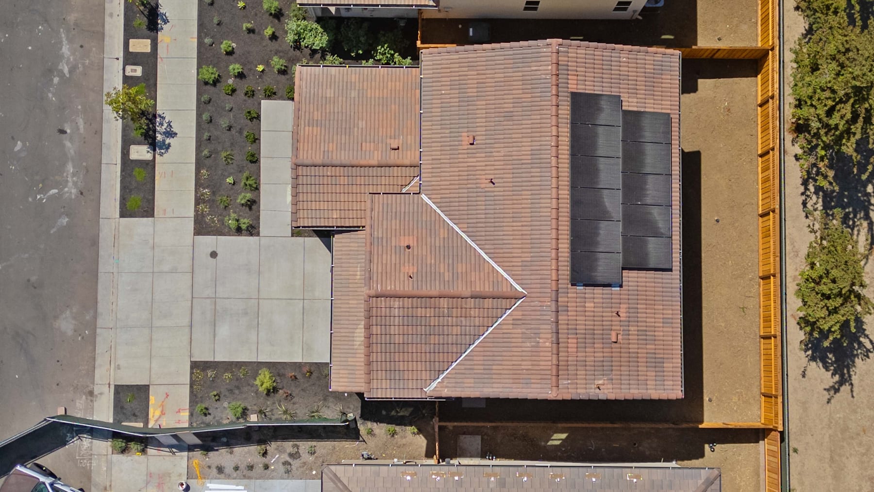 A multi-story building with a brick facade, surrounded by greenery and other structures, occupies the frame.