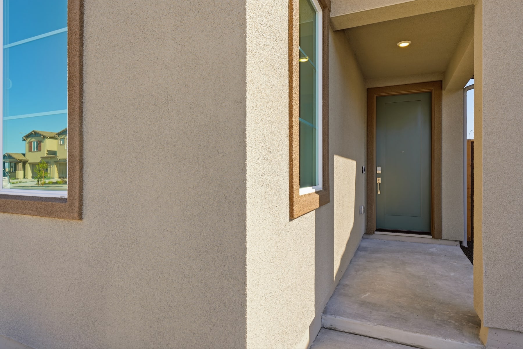 A hallway with a gray wall, a glass door, and a view of a building in the background.