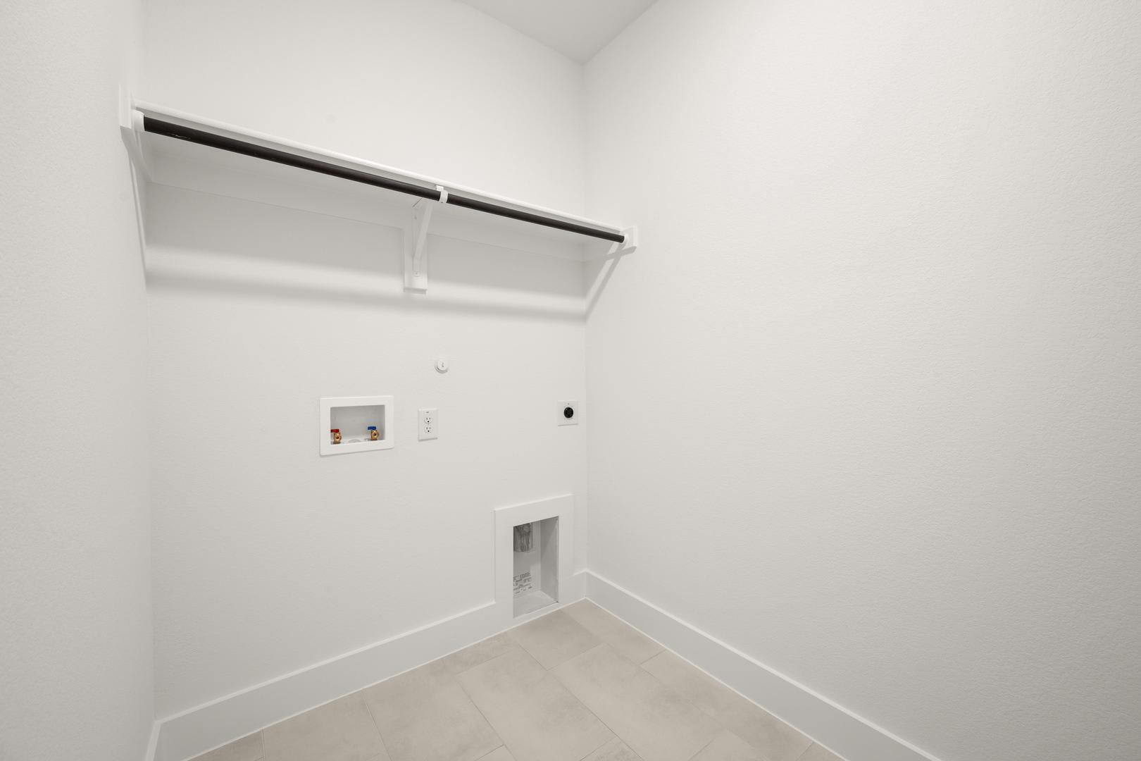 A minimalist, white-walled room with a recessed ceiling and a light switch on the wall.