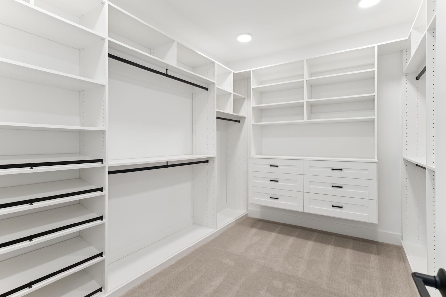 A spacious, well-organized walk-in closet with ample shelving, drawers, and hanging space, providing an efficient and visually appealing storage solution.