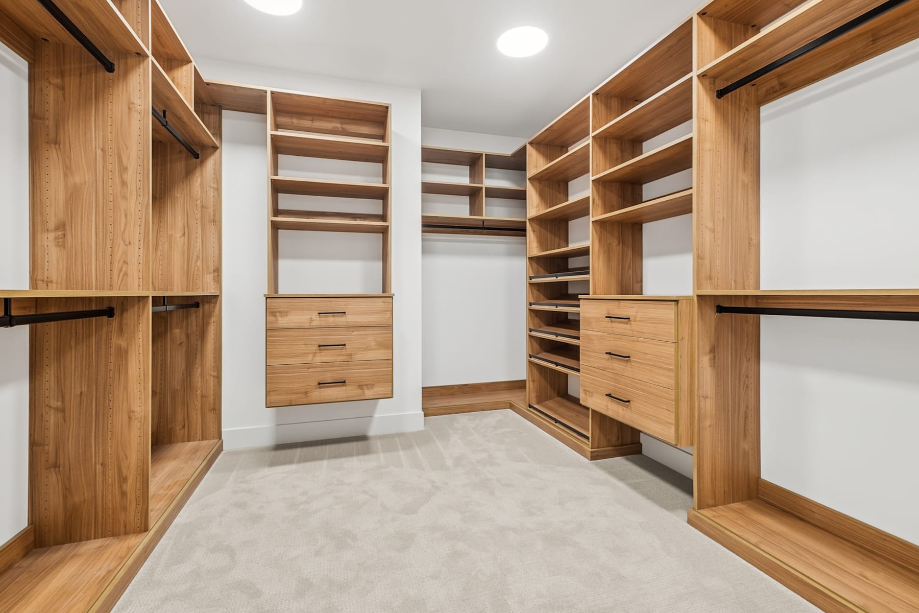 A spacious and well-organized walk-in closet with wooden shelves and drawers, providing ample storage space.