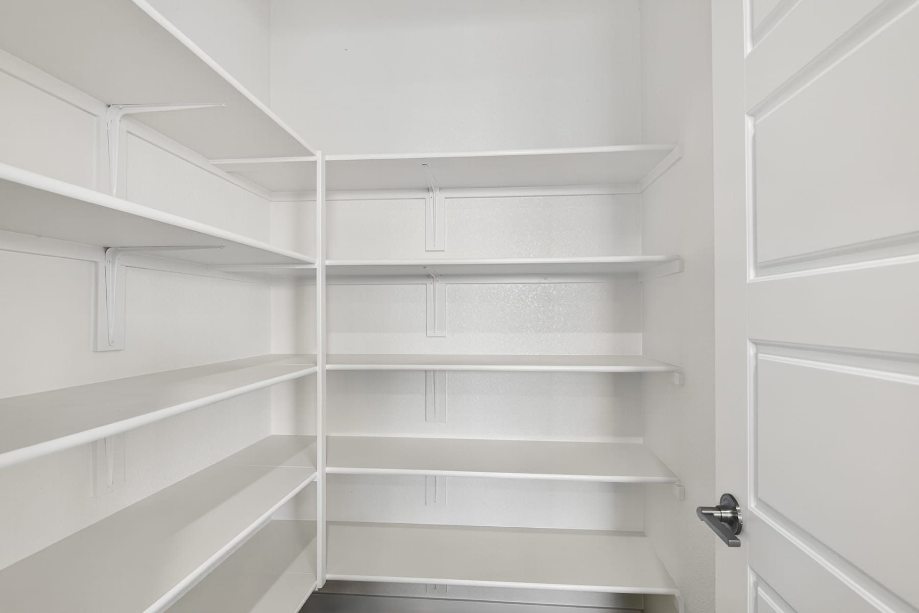 A spacious, well-organized walk-in closet with multiple shelves and storage space, providing ample room for storage and organization.