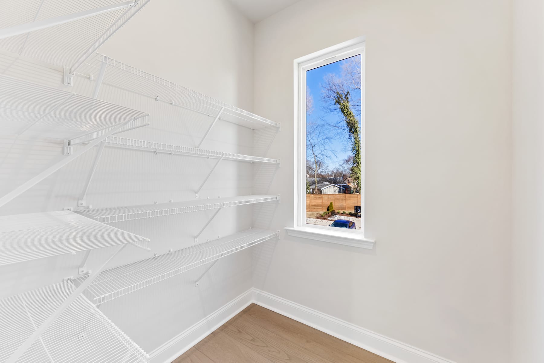 A bright, narrow window frames a view of a snowy outdoor scene, with shelves lining the walls in the foreground.