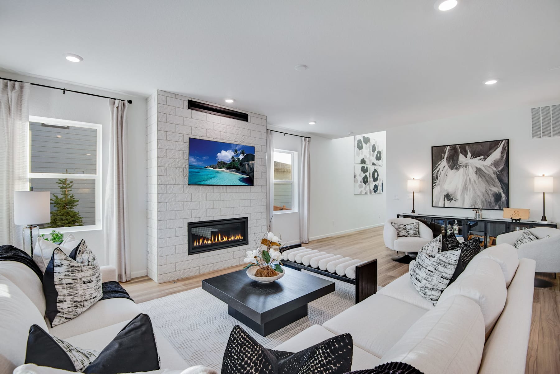 A modern and cozy living room with a fireplace, artwork, and comfortable furniture arranged in a stylish and inviting manner.