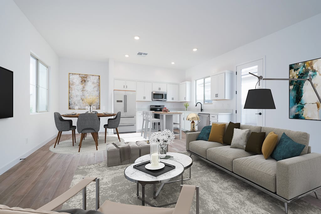 A modern and minimalist living room with a gray sofa, a round coffee table, and a dining area with a white table and chairs, all set against a bright and airy backdrop.