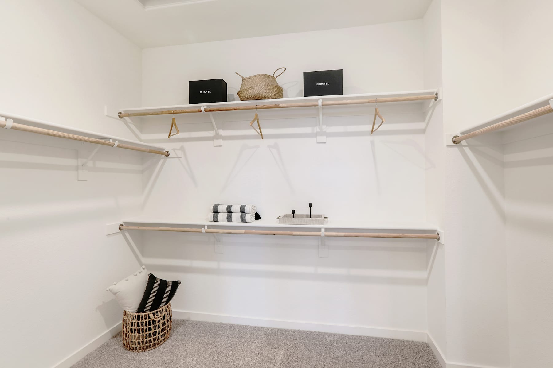 A well-organized closet with wooden shelves, storage containers, and a hanging rod for clothes.