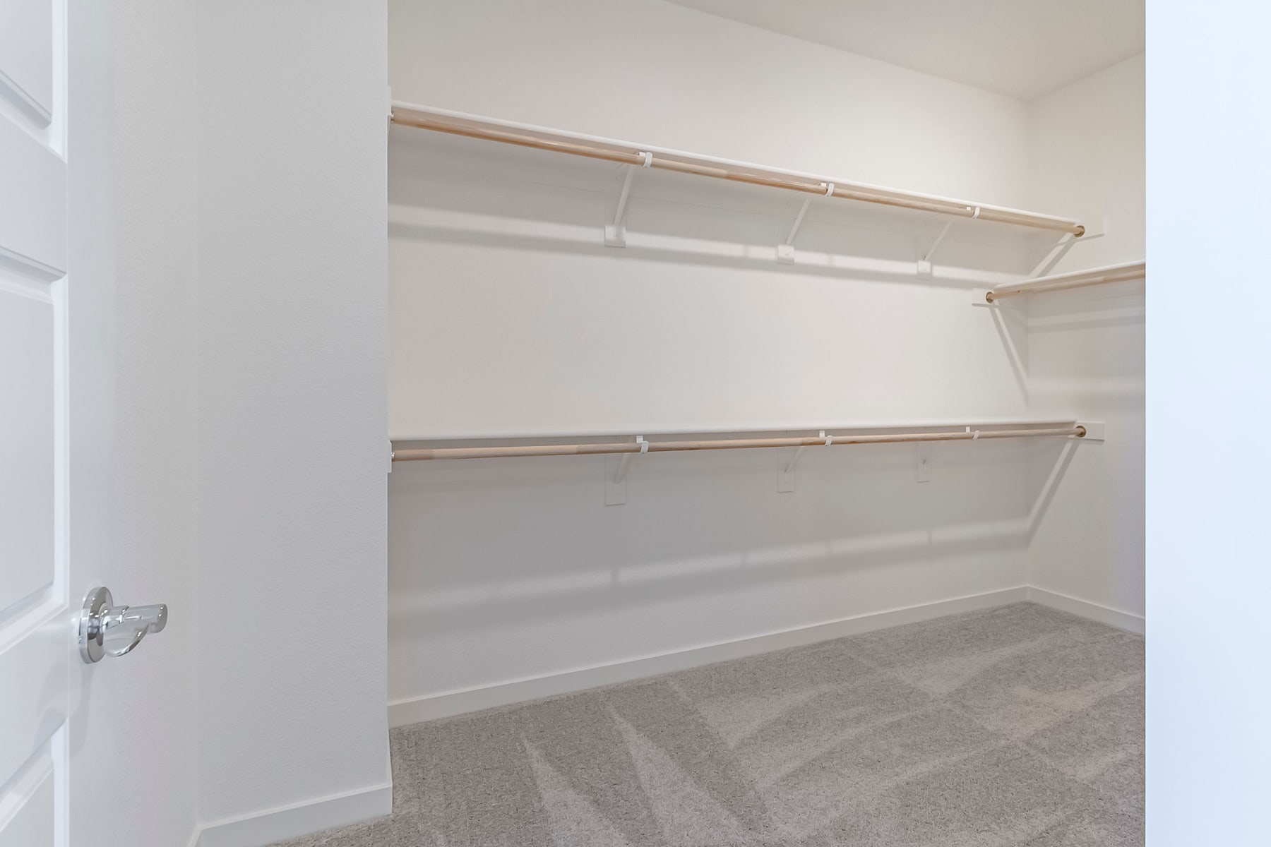 An empty closet with white walls and shelves, providing ample storage space.
