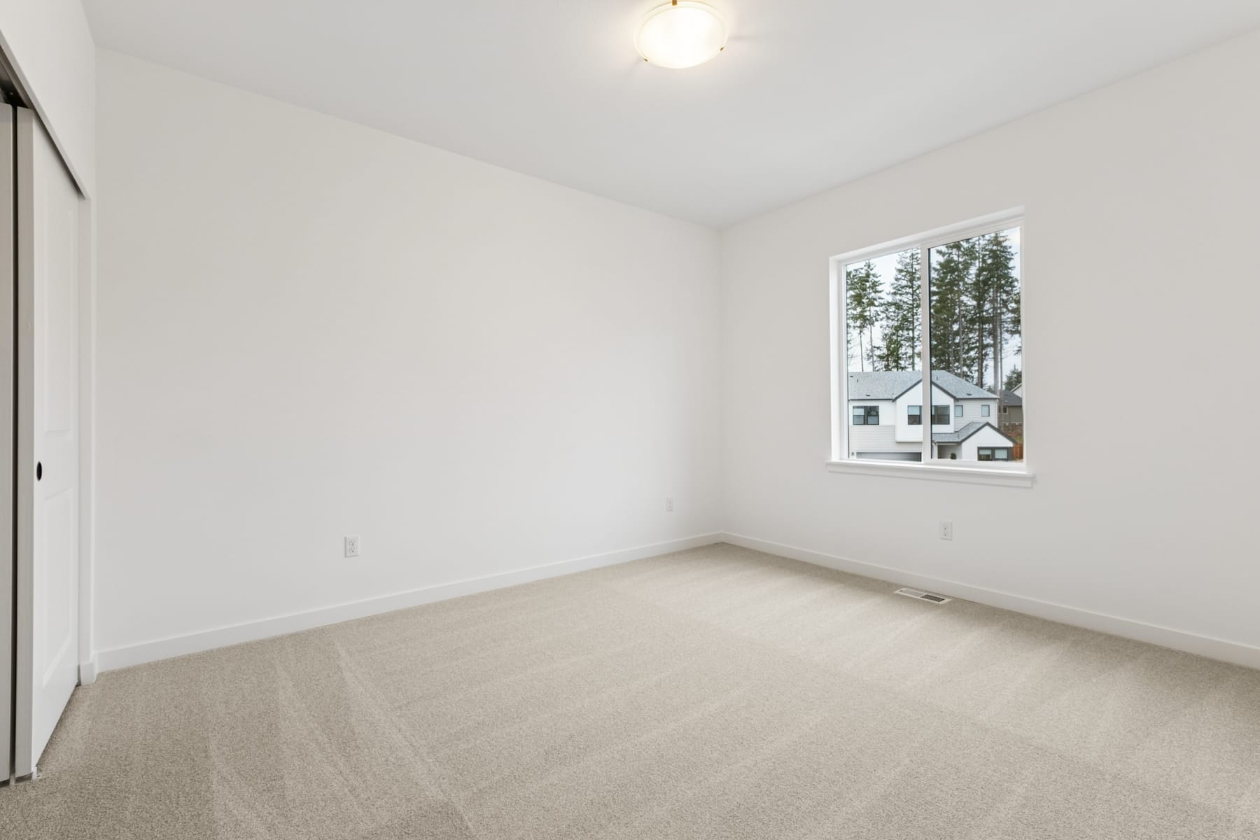 A bright, empty room with a large window overlooking a snowy landscape in the background.
