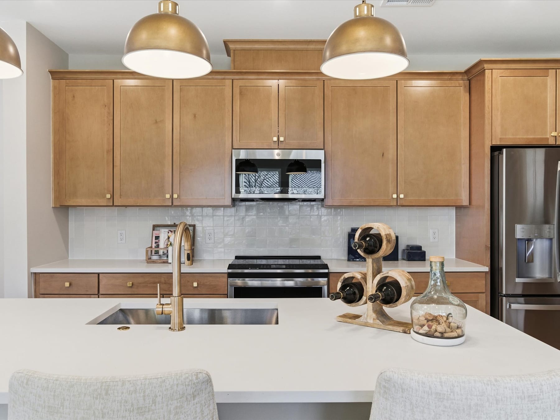 A modern kitchen with wooden cabinets, stainless steel appliances, and decorative elements on the countertop.