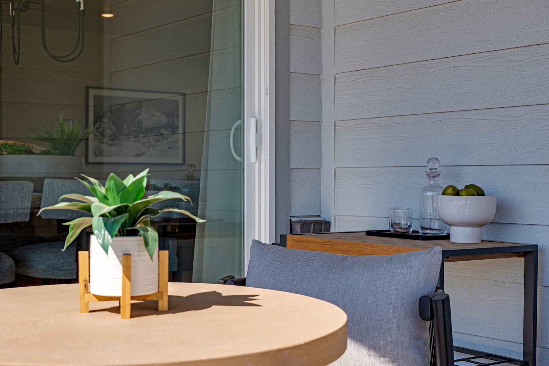 A cozy and inviting indoor space with a round wooden table, a potted plant, and various decorative elements in the background, creating a warm and welcoming atmosphere.