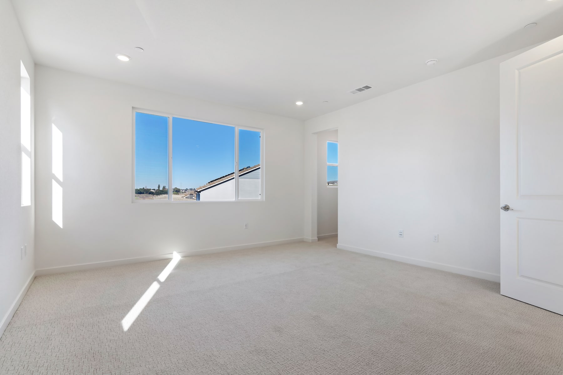A bright, spacious room with large windows offering a view of the cityscape in the background.