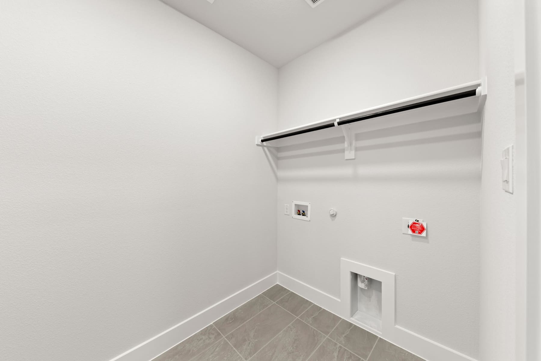 A small, white-walled room with a closet and a red fire extinguisher mounted on the wall.