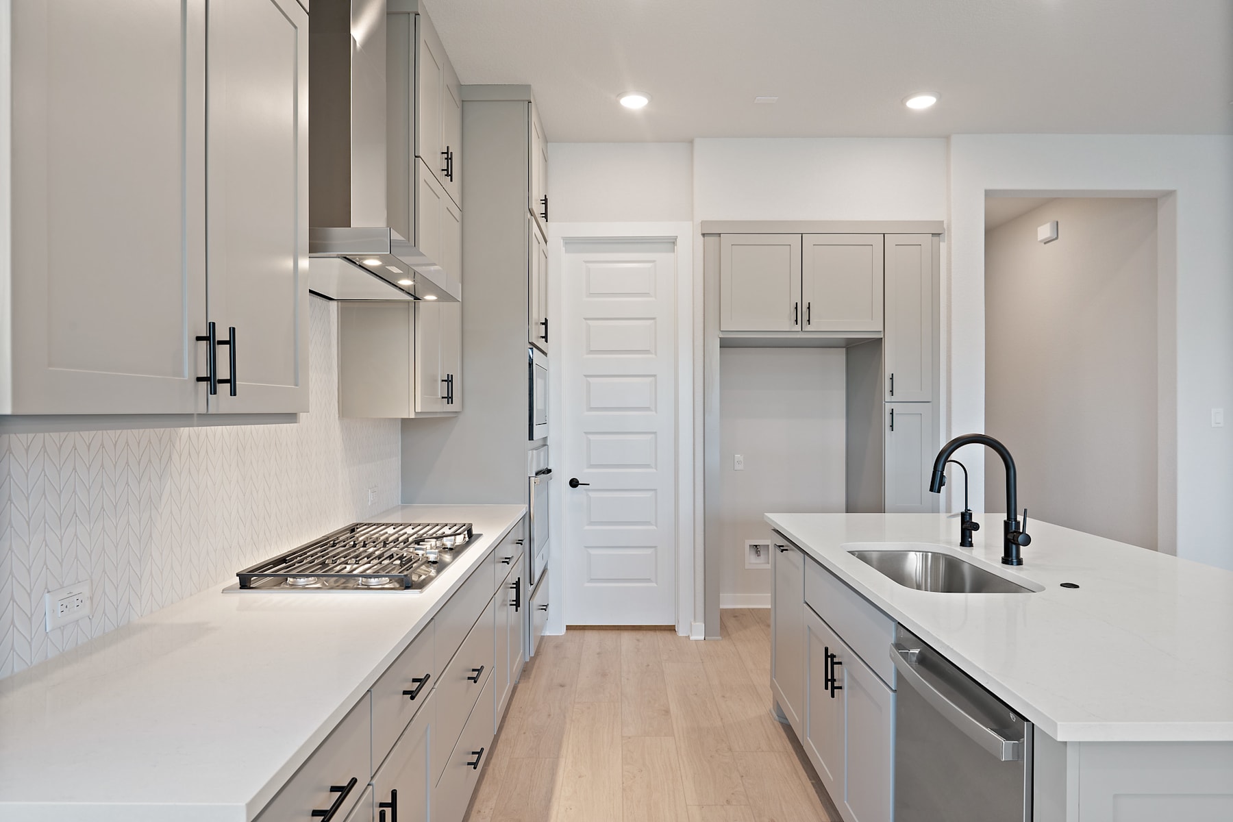 A modern, minimalist kitchen with white cabinets, stainless steel appliances, and a sleek, clean design.