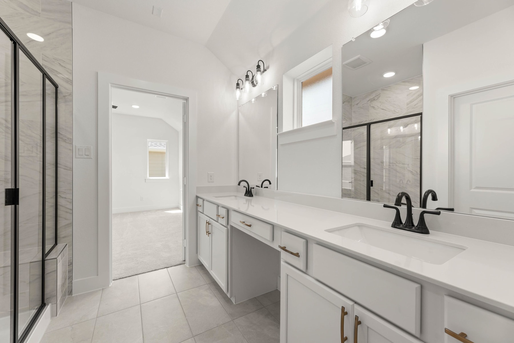 A modern, minimalist bathroom with white cabinets, a double vanity, and a glass-enclosed shower area, all set against a bright, airy backdrop.