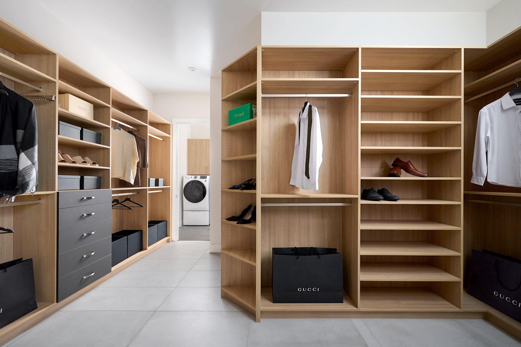 A spacious and well-organized walk-in closet with wooden shelves, drawers, and hanging space for various clothing and accessories.