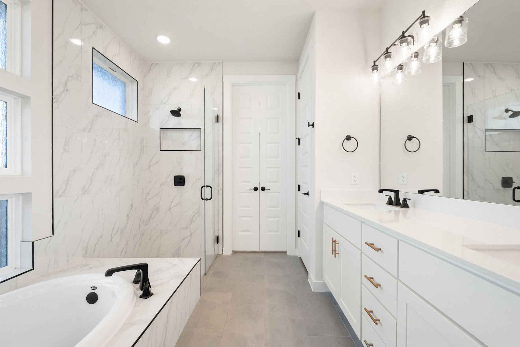 A modern, minimalist bathroom with a white marble-like vanity, a freestanding bathtub, and a glass-enclosed shower area, all set against a bright, airy backdrop.