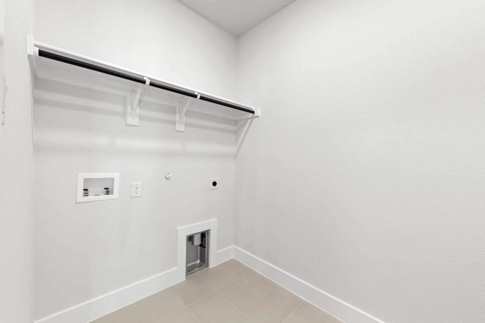 A minimalist, white-walled room with a closet system and a power outlet visible on the wall.
