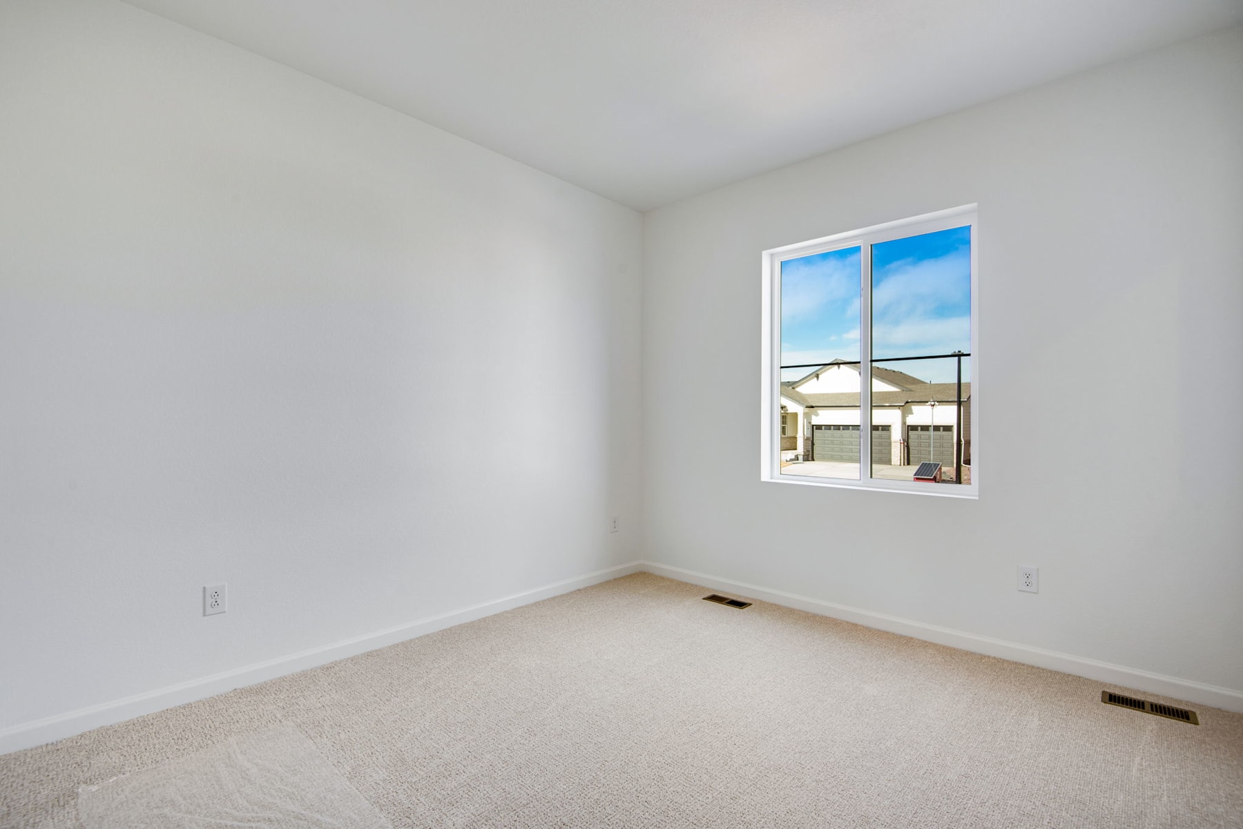 A bright, empty room with a large window overlooking a scenic outdoor landscape.