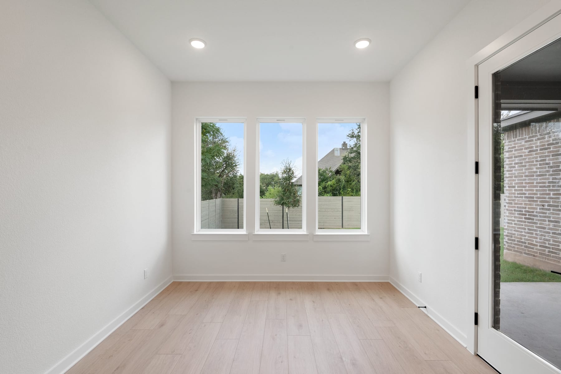 A bright and spacious room with large windows overlooking a lush, green outdoor landscape.