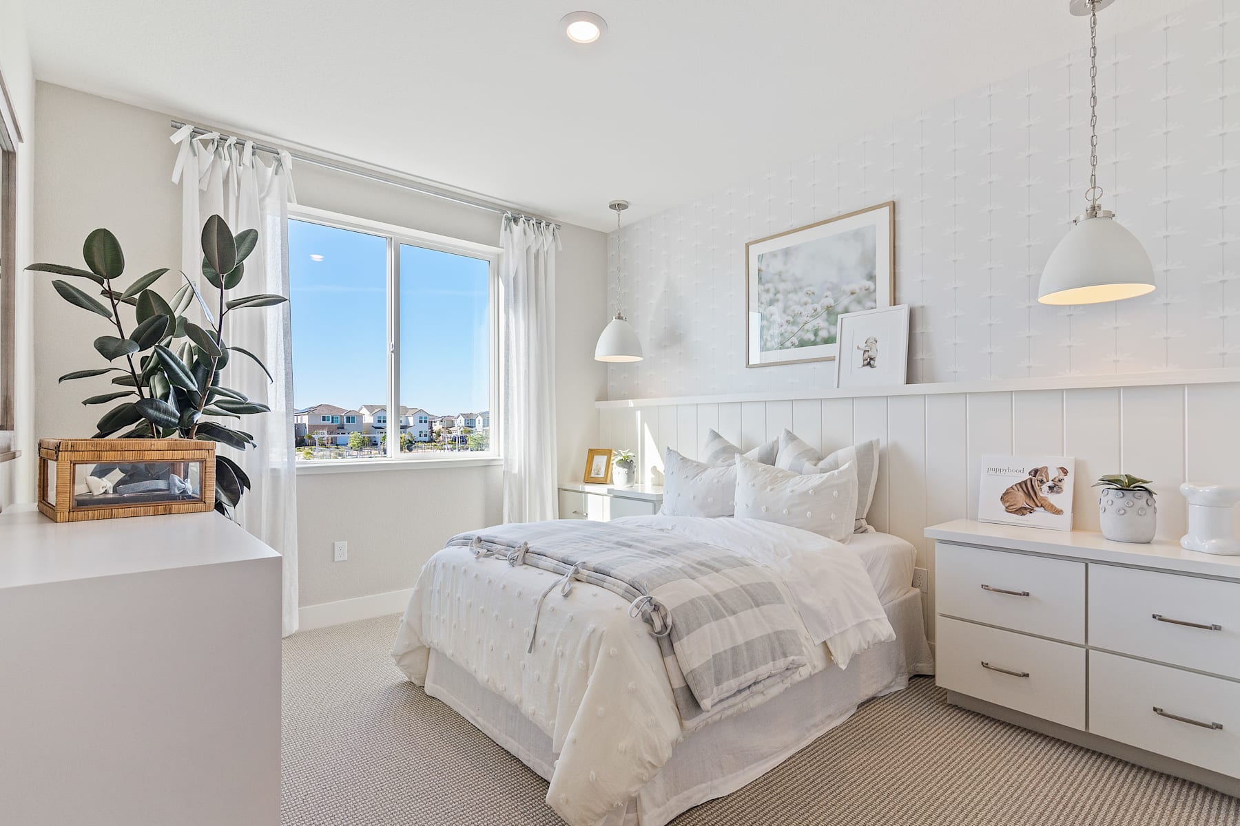 A cozy and well-designed bedroom with a large window overlooking a cityscape, featuring a comfortable bed, minimalist decor, and various decorative elements.