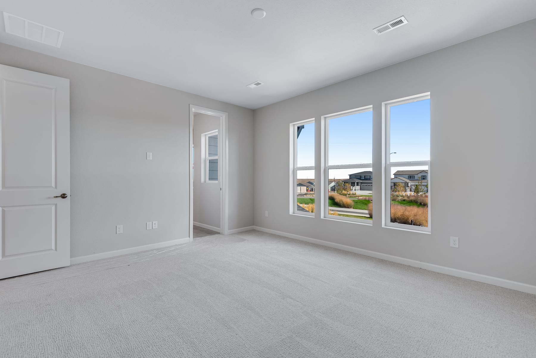 A spacious, well-lit room with large windows overlooking a scenic outdoor landscape, featuring a neutral color palette and clean, minimalist design.