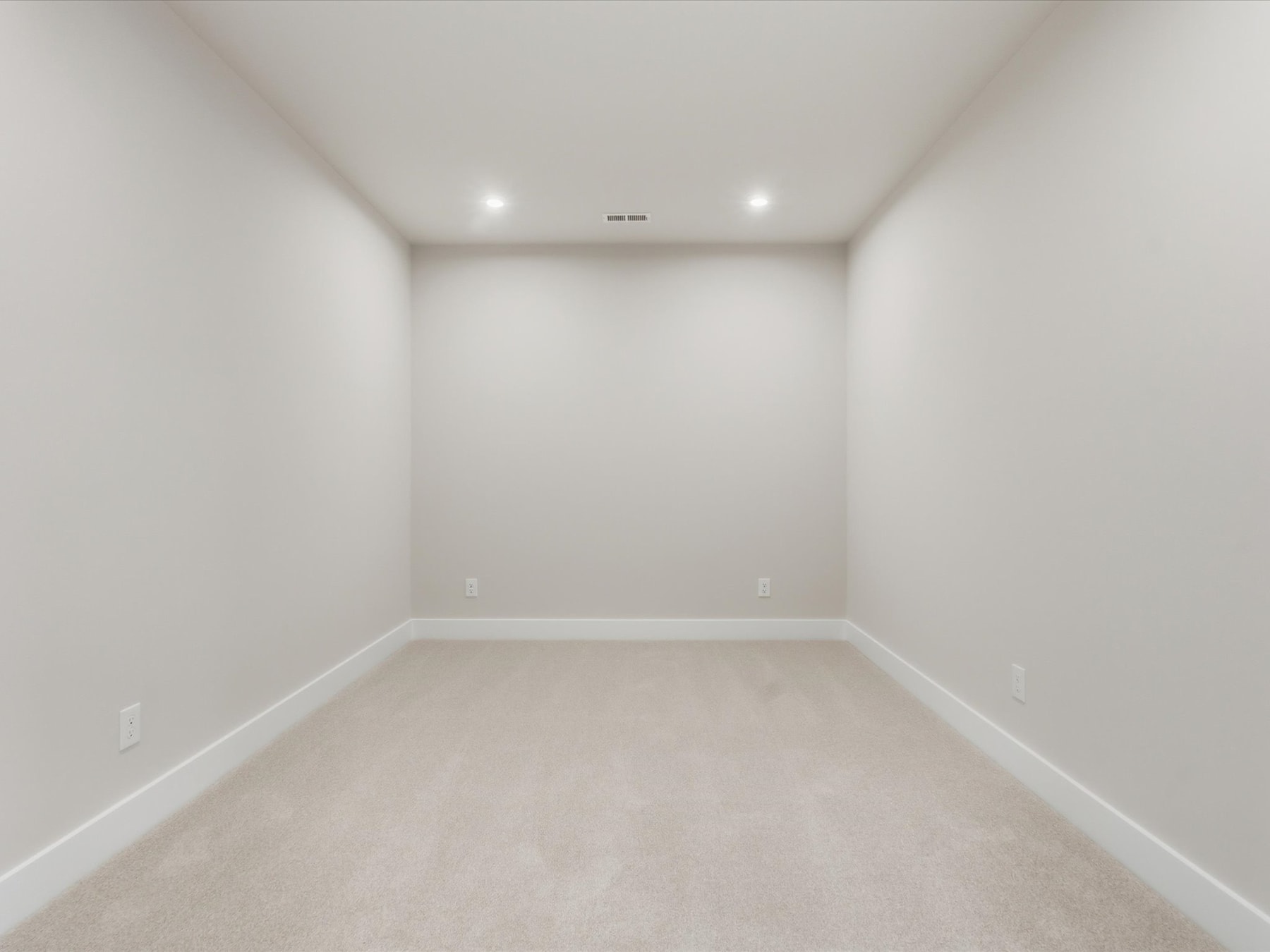 A simple, minimalist room with white walls and a light-colored floor, creating a clean and spacious atmosphere.