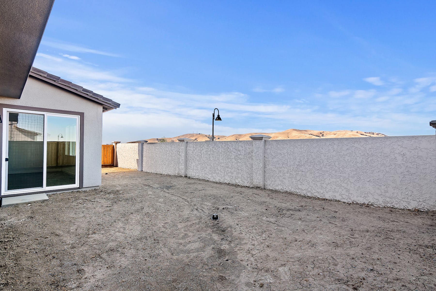 A newly constructed residential building with a paved outdoor area and a clear blue sky in the background.