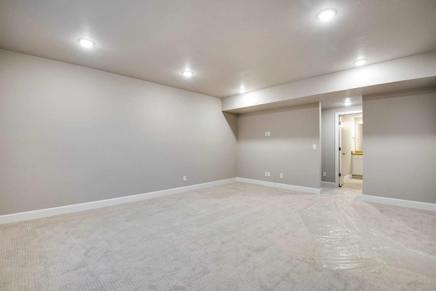 A spacious, well-lit room with a smooth, light-colored floor and plain white walls, creating a clean and minimalist atmosphere.