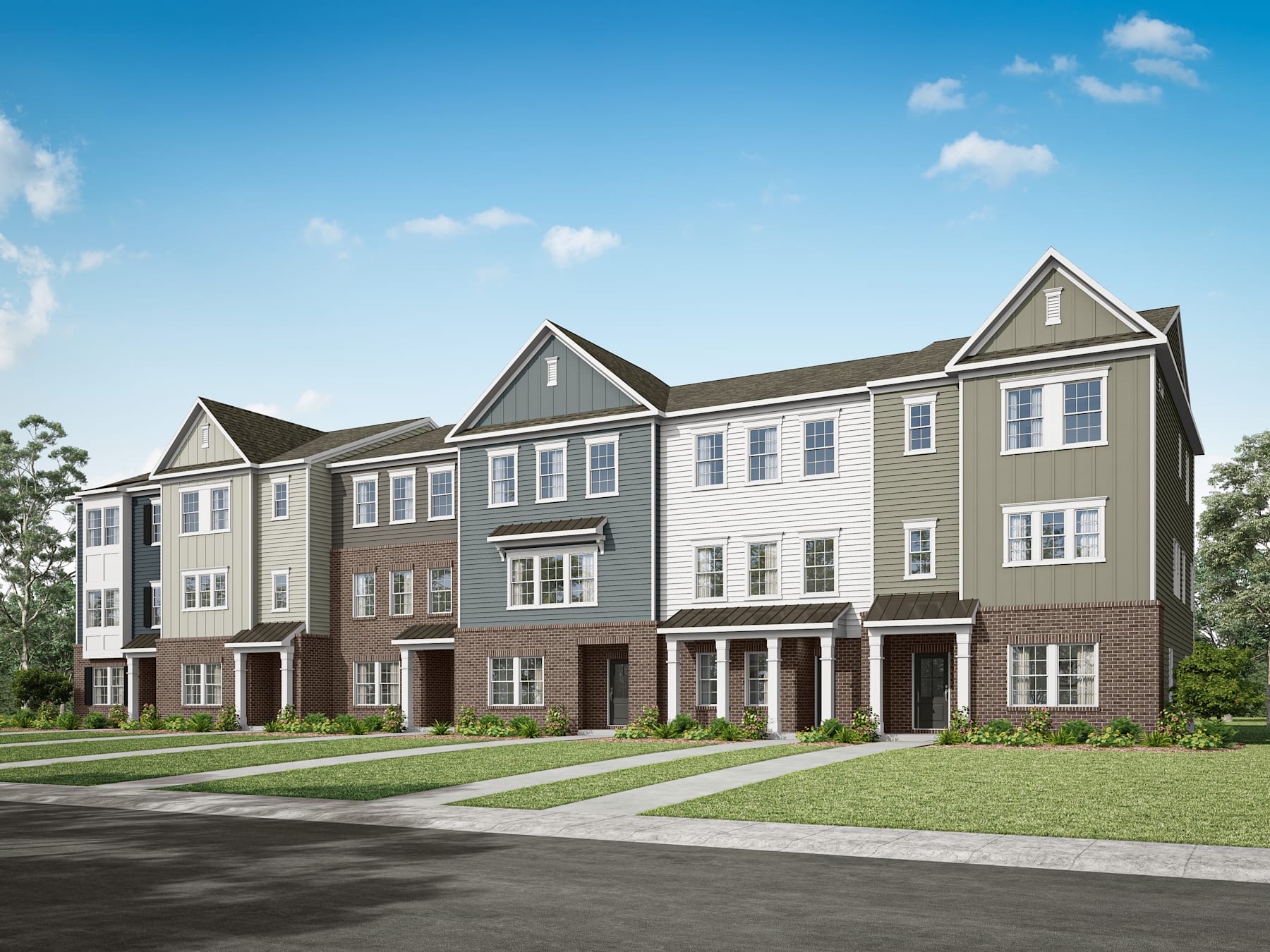 A row of modern, multi-story townhouses with gabled roofs and siding in neutral tones, set against a backdrop of a clear blue sky with scattered clouds, surrounded by a grassy lawn in the foreground.