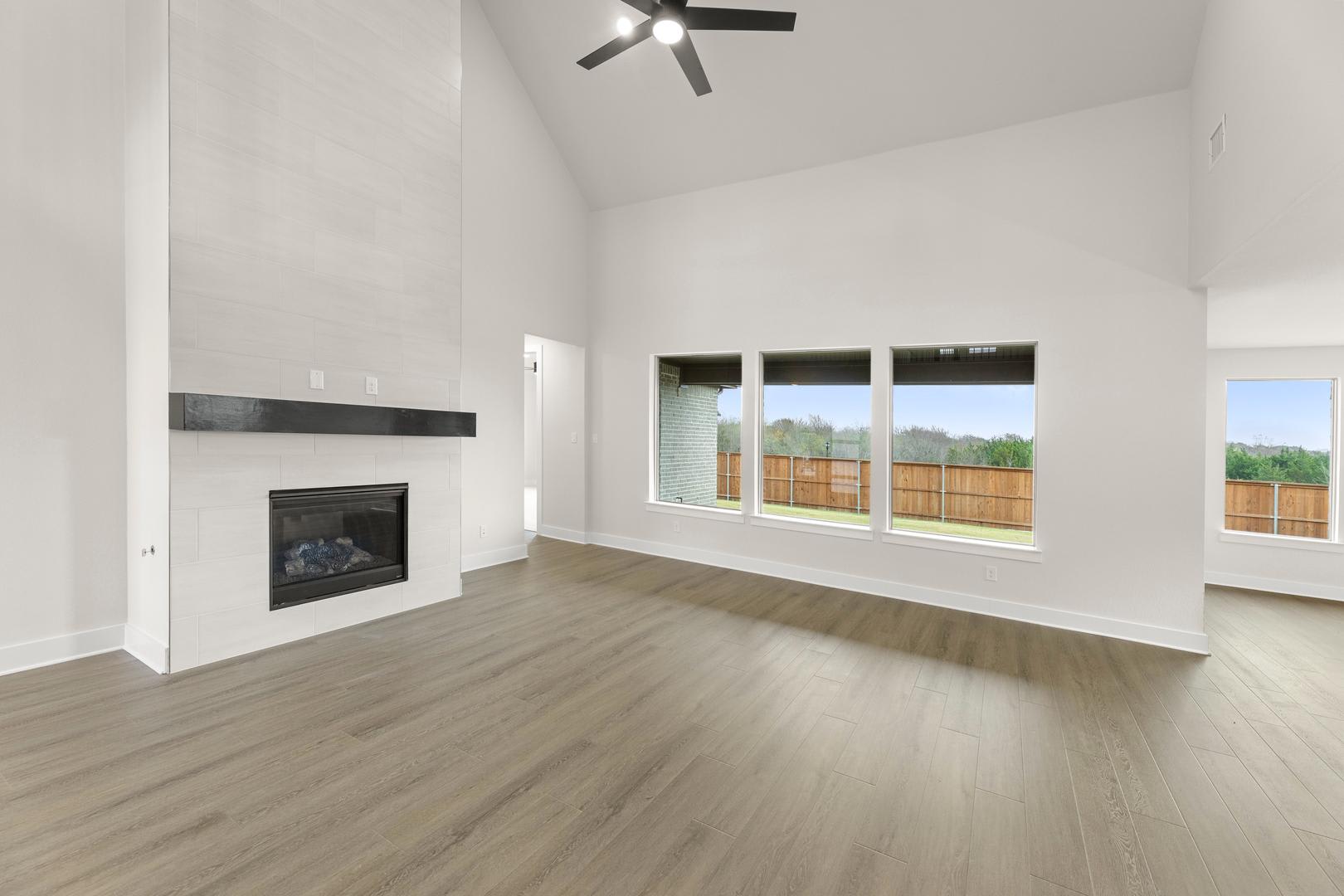 A spacious, bright room with a fireplace and large windows overlooking a scenic outdoor view.