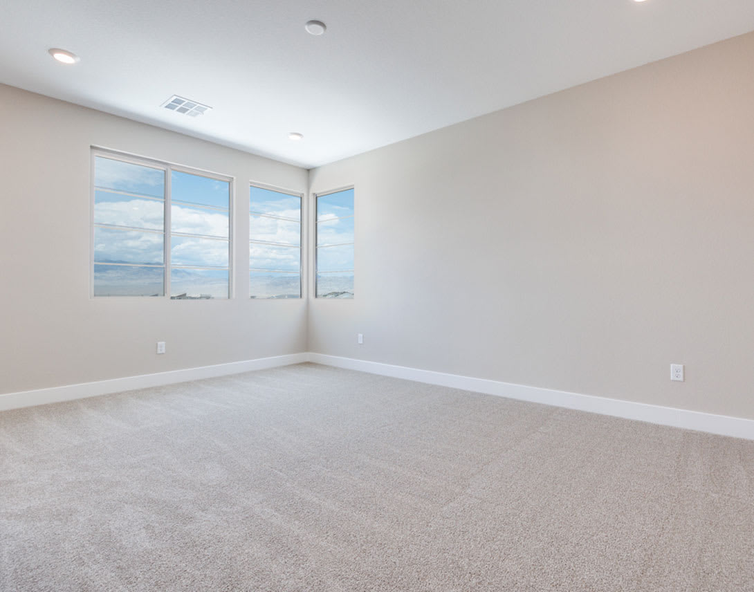 A spacious, bright room with large windows overlooking a scenic outdoor view, featuring a clean, minimalist design with a neutral color palette and plush carpeting.