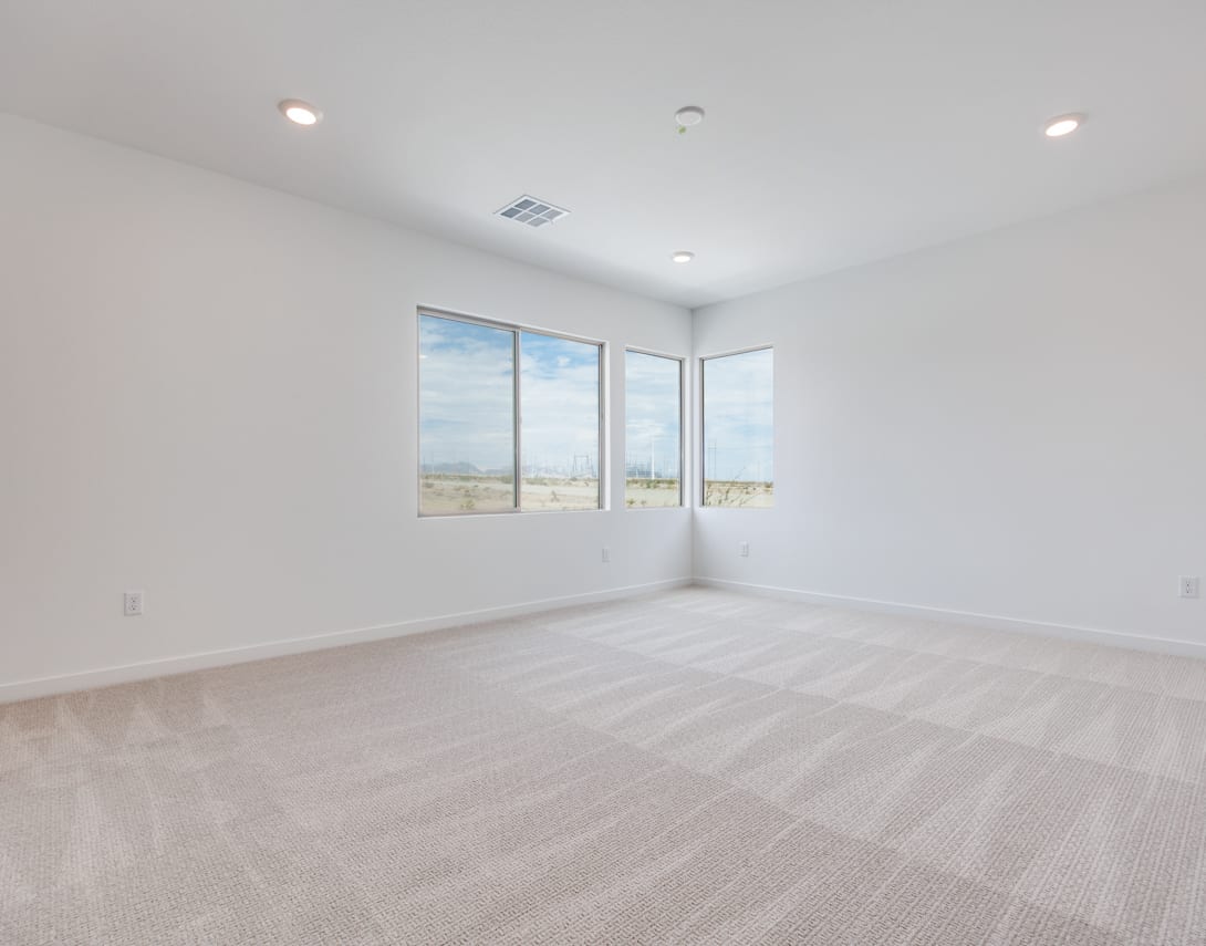 A bright, spacious room with large windows overlooking a scenic outdoor landscape, featuring a clean and minimalist interior design with hardwood floors.
