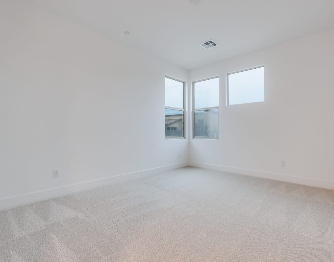 An empty, bright room with large windows, a clean and minimalist interior design.
