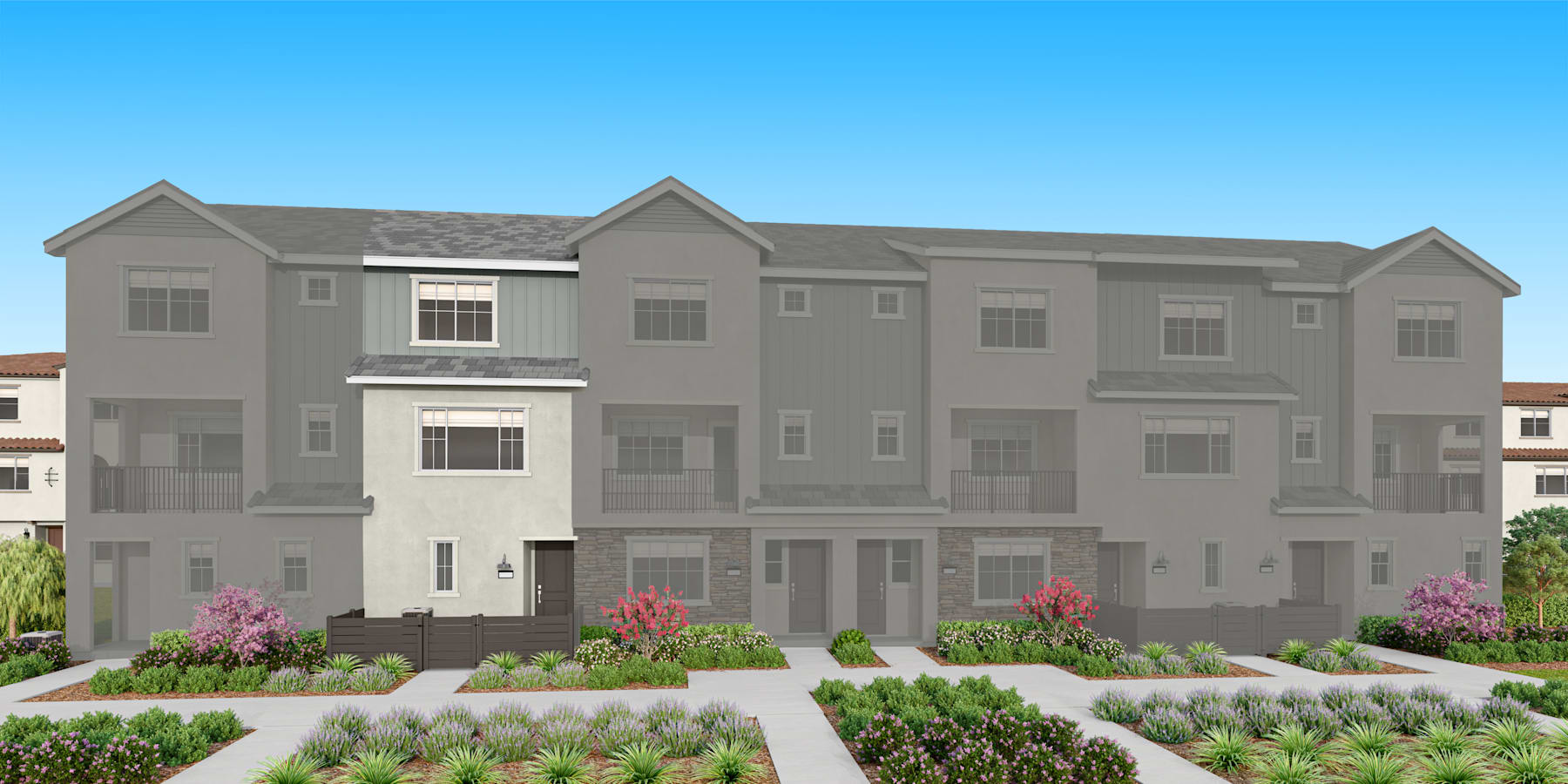 A multi-story residential building with a gray exterior, surrounded by landscaped gardens and a clear blue sky in the background.