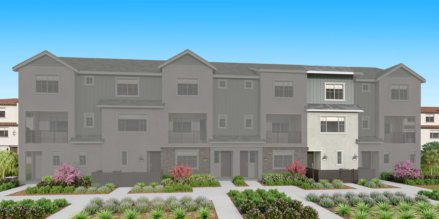 A multi-story residential building with a gray exterior, surrounded by landscaped gardens and a clear blue sky in the background.