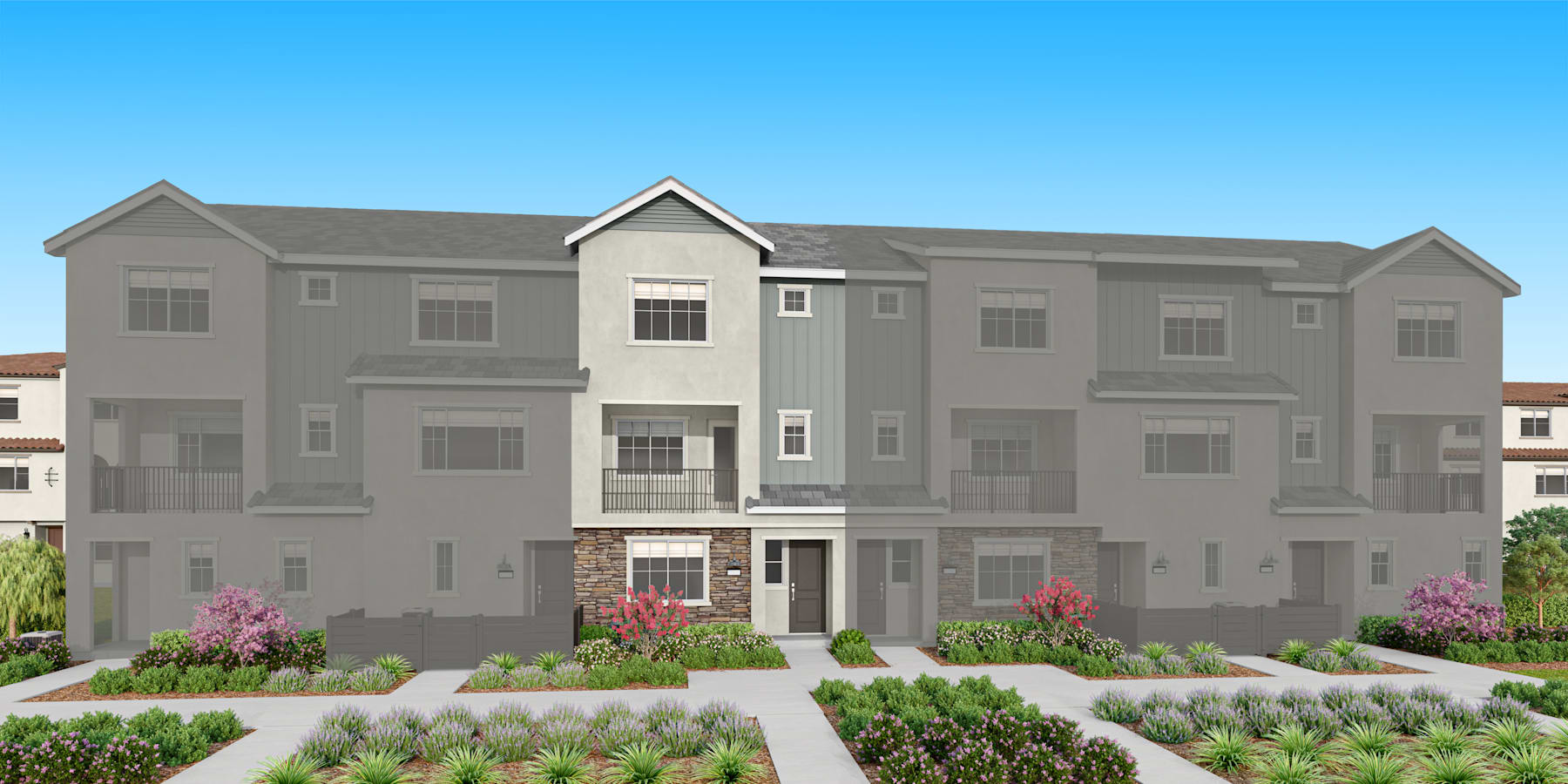 The image depicts a multi-story residential building with a gray exterior, featuring a landscaped front yard with various plants and flowers.