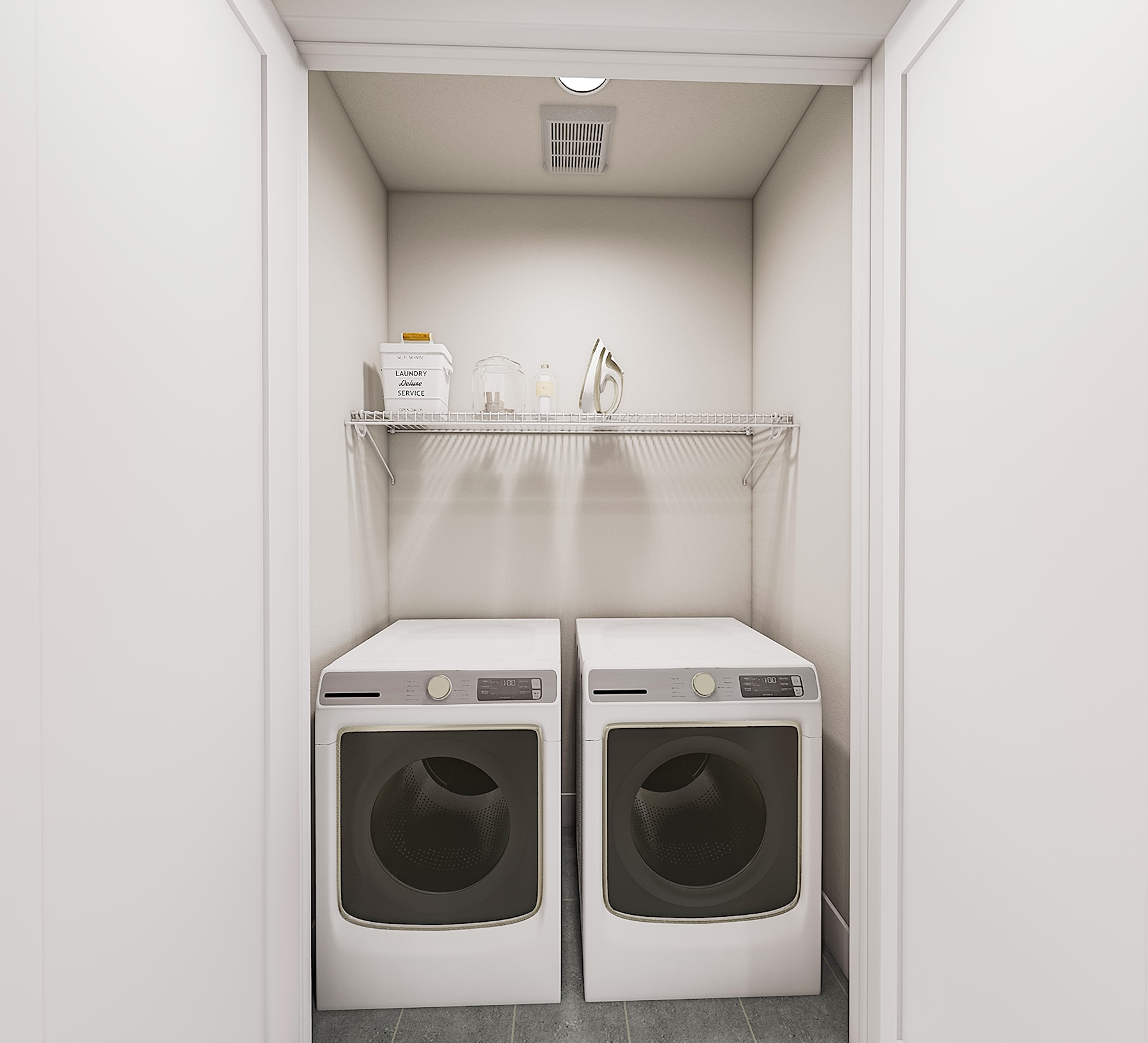 A small, white laundry room with a washer and dryer set up against the wall, along with a wire shelving unit above them.