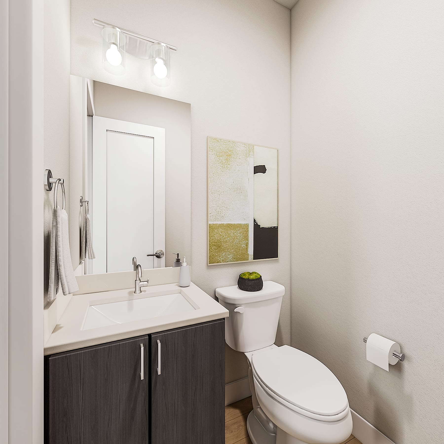 A modern and minimalist bathroom with a dark vanity, a white sink, and a framed artwork on the wall.