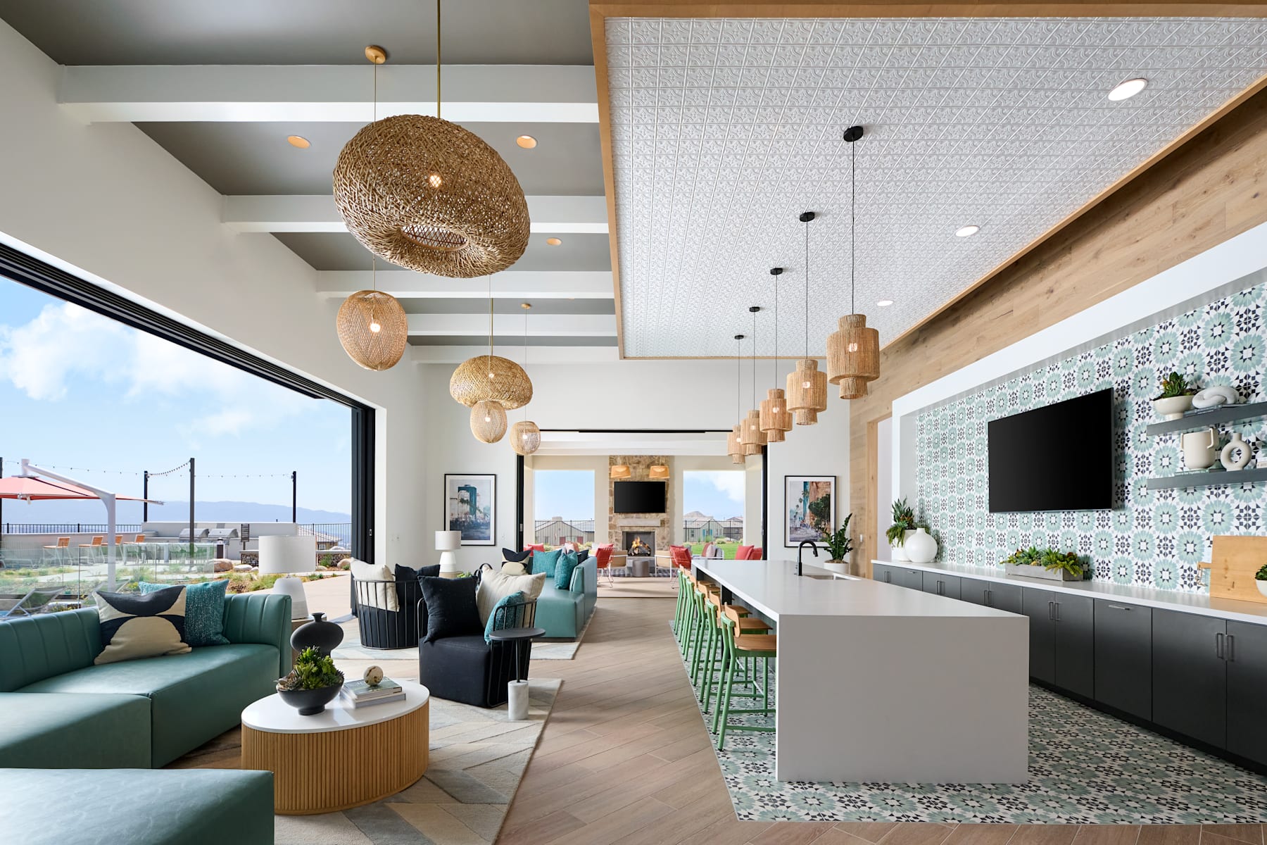 A modern and stylish living room with comfortable sofas, pendant lighting, and a scenic view through the large windows.