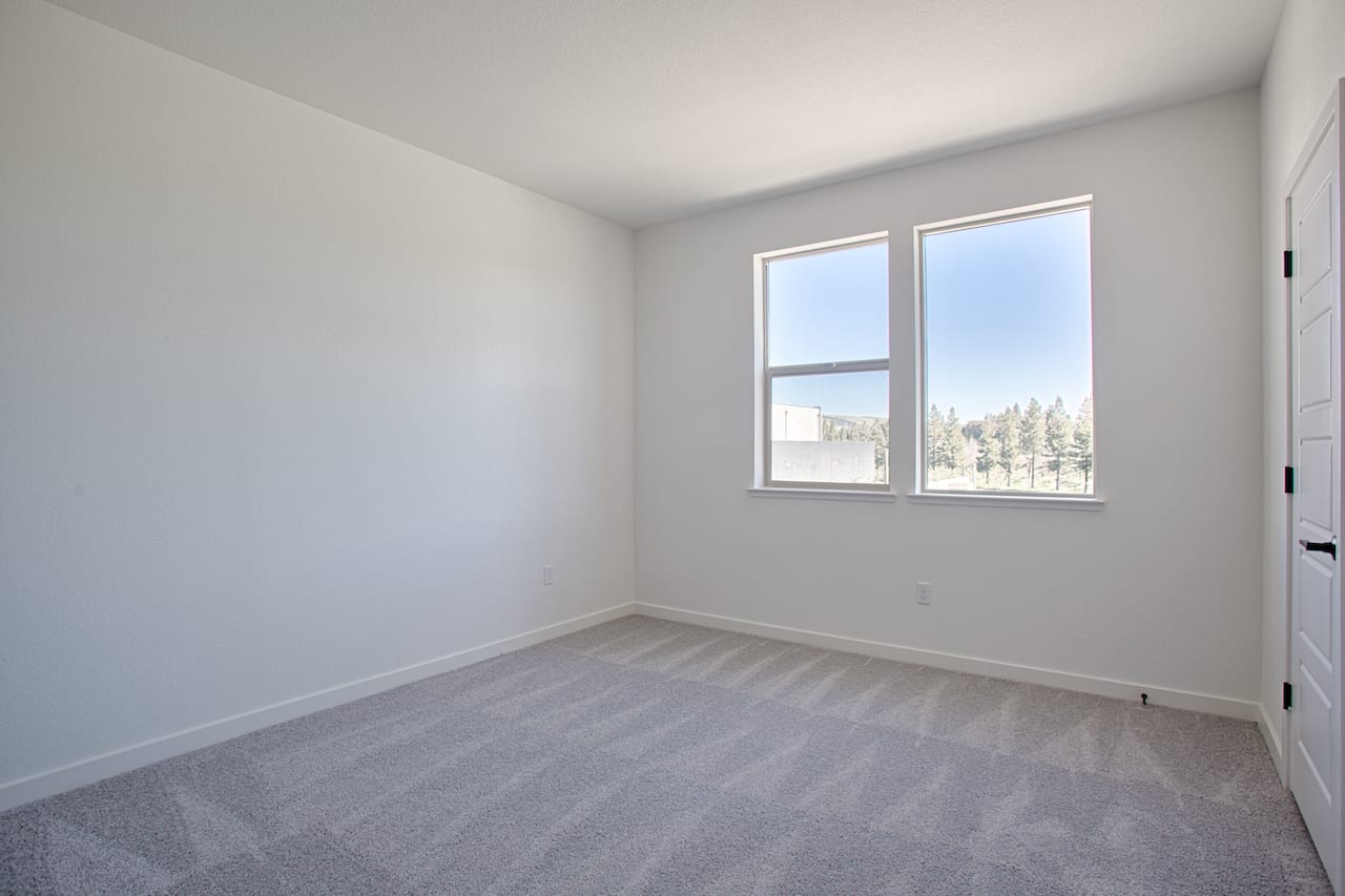 A bright, empty room with a large window overlooking a snowy landscape.