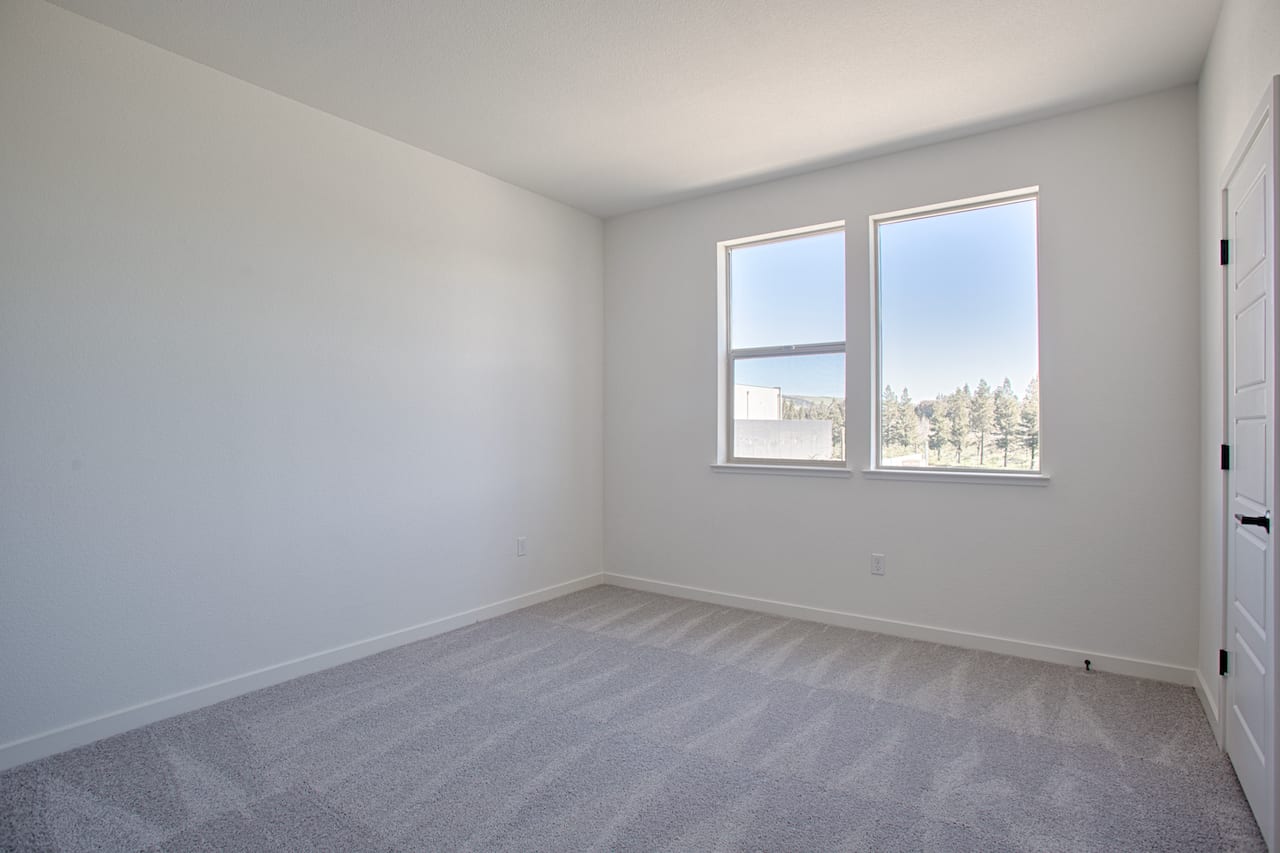 A spacious, well-lit room with a large window overlooking a scenic outdoor view, featuring a clean and minimalist interior design.