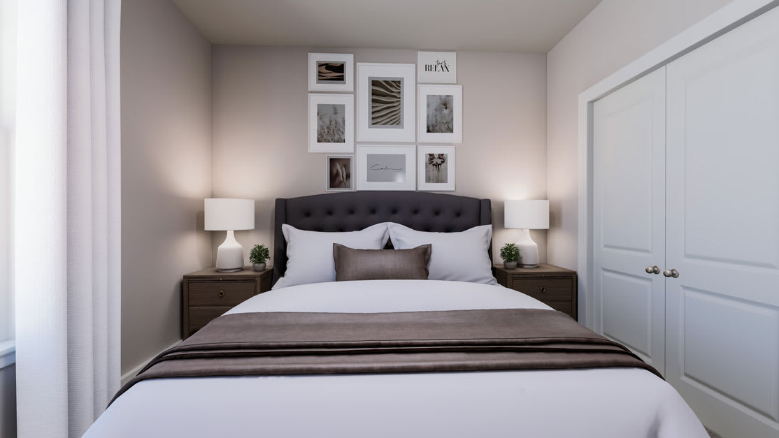 A cozy and well-designed bedroom with a tufted headboard, nightstands, and a gallery wall of framed artwork above the bed.