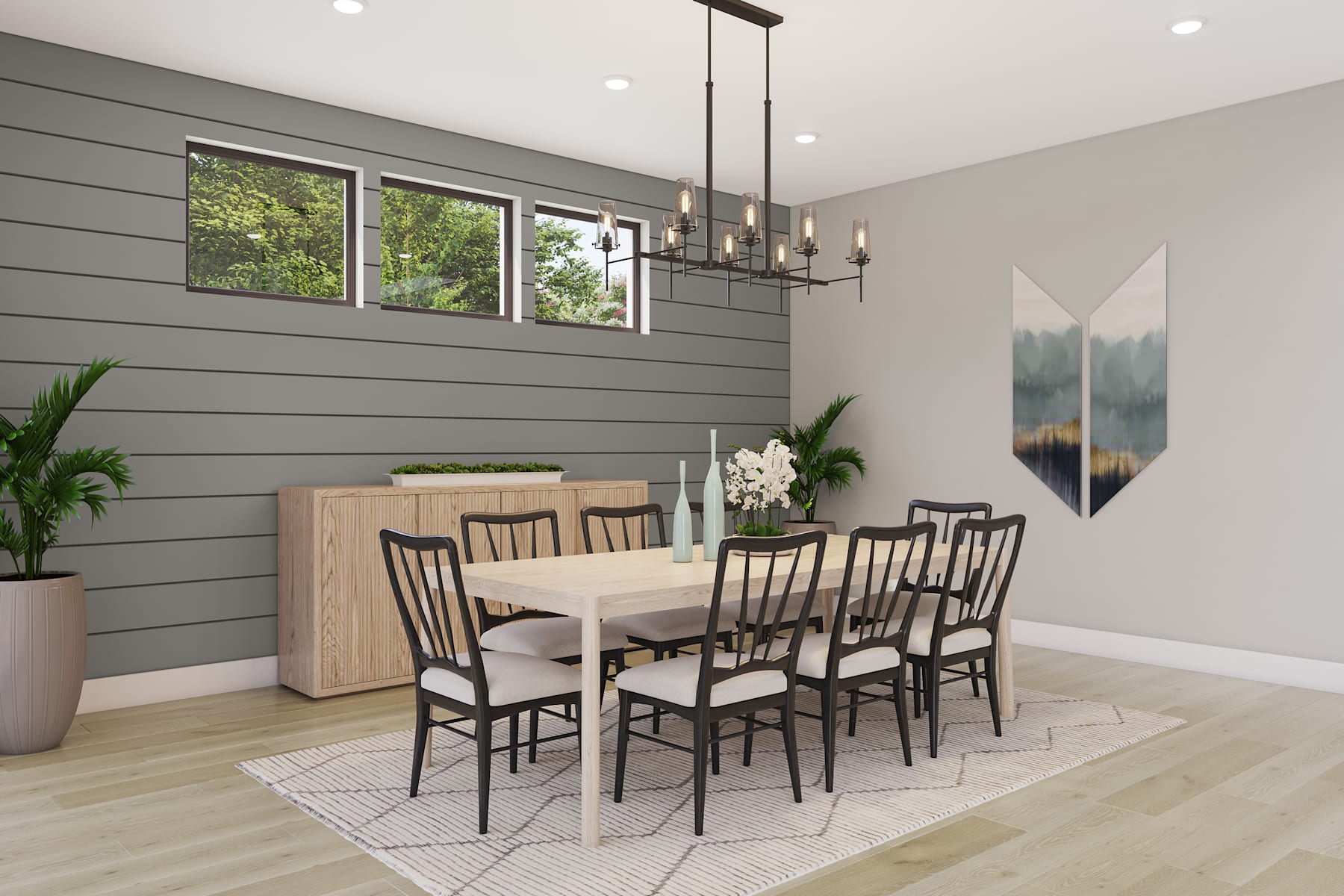 A modern and minimalist dining room with a wooden table, black chairs, and a large window overlooking greenery outside.