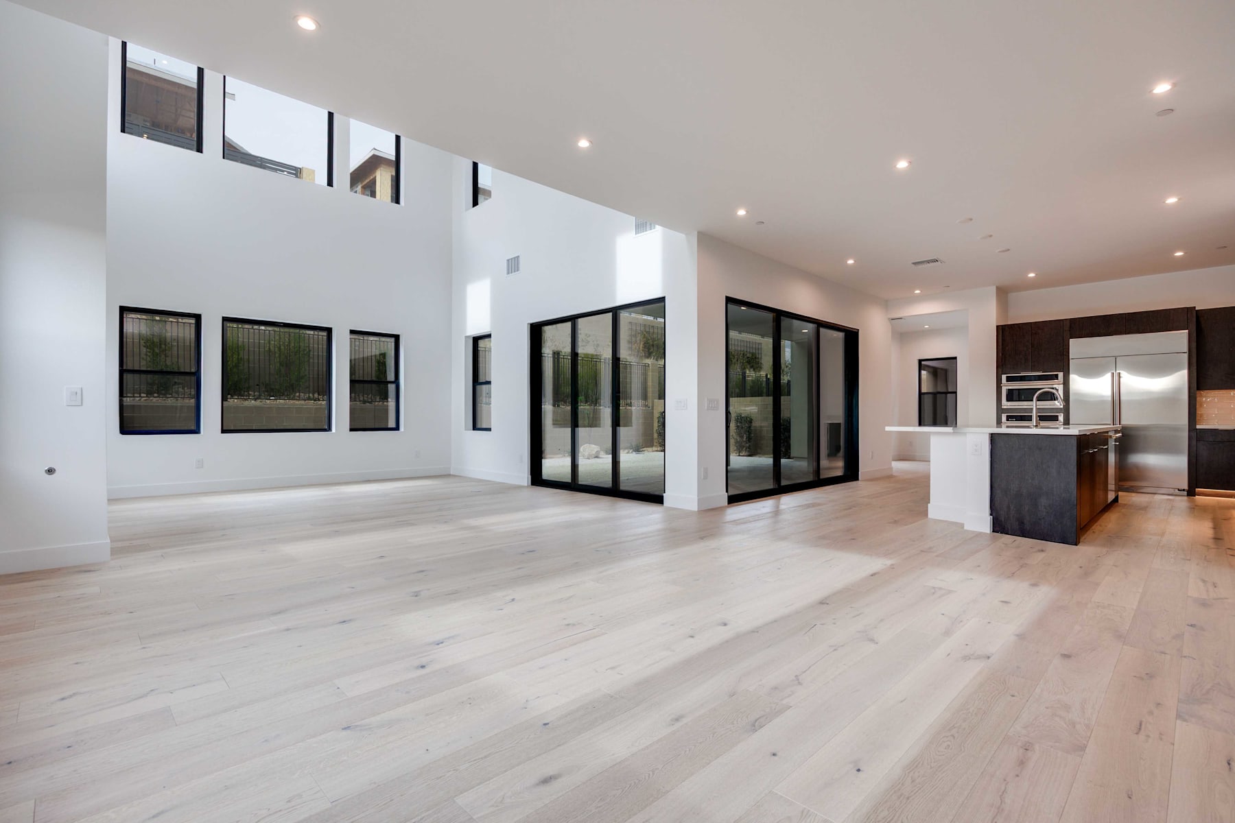 A spacious, modern interior with large windows, hardwood floors, and a minimalist design aesthetic.