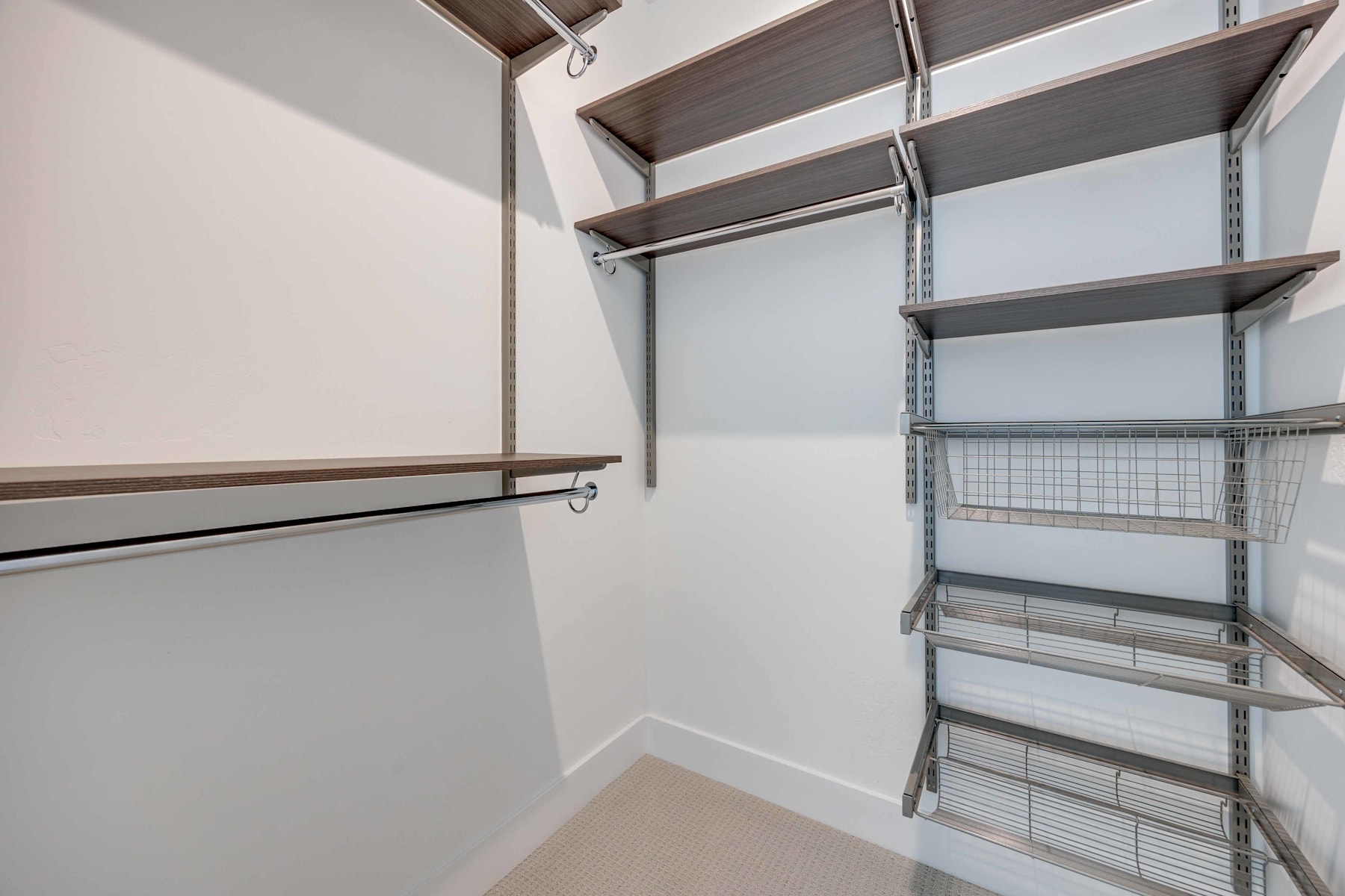 A well-organized walk-in closet with shelves, hanging rods, and a storage system, providing ample space for organizing and storing various items.